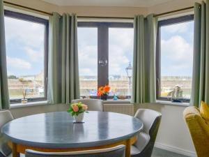 a dining room with a table and windows at Harbour Watch in Maryport