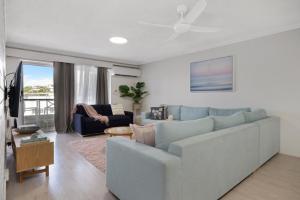 a living room with a couch and a ceiling fan at Luna Blu - Private Apartment Yeppoon in Yeppoon