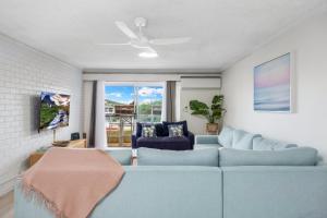 a living room with a blue couch and a window at Luna Blu - Private Apartment Yeppoon in Yeppoon