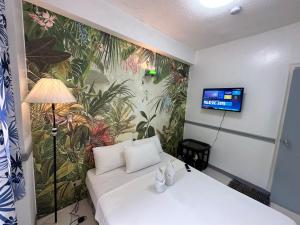 a room with a white couch and a wall mural at Generosa Beach Club in Bauang