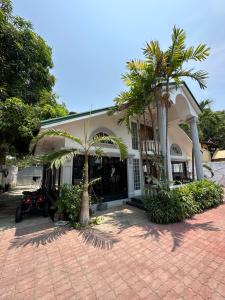 een huis met een palmboom ervoor bij Generosa Beach Club in Bauang