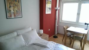 een slaapkamer met een bed, een tafel en een raam bij Apartment Kapishtec in Skopje