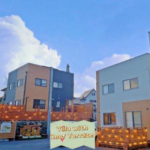 un edificio con un letrero que dice ganar con terraza en la azotea en ヴィラ山間堂 Terrace Villa BBQ Bonfire Fuji view Annovillas, en Fujikawaguchiko