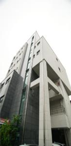 a tall white building with people on it at Ho Home Tel in Seoul