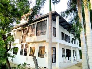 a white building with palm trees in front of it at Apartamento vacacional piscina in Nariño