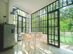 ein Esszimmer mit einem Tisch und großen Fenstern in der Unterkunft Apartamento vacacional piscina in Nariño