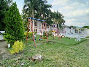 a park with a playground with a swing set at Apartamento vacacional piscina in Nariño