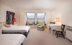 a bedroom with two beds and a desk and a chair at Tigh Chailein in Tarbert