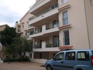 un coche azul estacionado frente a un edificio en Apartments Obala Dragovic, en Petrovac na Moru