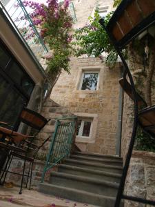 una escalera que conduce a un edificio con una ventana y flores en Apartments Obala Dragovic, en Petrovac na Moru