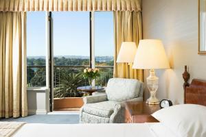 a bedroom with a bed and a chair and a window at Sir Stamford Circular Quay in Sydney