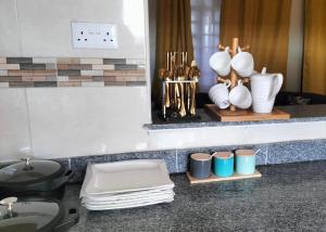 a counter with plates and vases and a sink at B’s homely in Ruiru