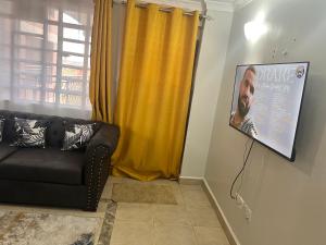 uma sala de estar com um sofá e um cartaz na parede em B’s homely em Ruiru