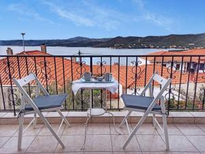 una mesa y sillas en un balcón con vistas al océano en Doras House in village Άνετο Διαμέρισμα υπέροχη θέα, en Pyrgadikia