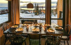 a dining room table with a view of the snow at Awesome Home In Rauland With Sauna in Rauland