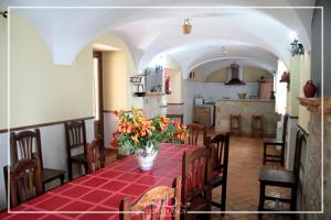 a dining room with a table with a vase of flowers at Casa Rural Doña Blanca in Santa Cruz de la Sierra