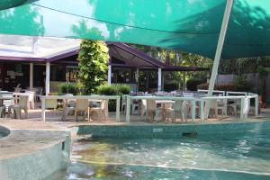 a patio with tables and chairs next to a swimming pool at Aurora Kakadu Lodge in Jabiru