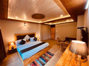 a bedroom with a bed and a table and a lamp at Sana cottage - Affordable Luxury Stay in Manali in Manāli