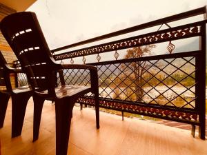 a chair sitting on a balcony with a view at Sana cottage - Affordable Luxury Stay in Manali in Manāli