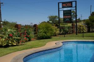 Mildura Riverview Motel في Gol Gol: حمام سباحة مع وجود علامة موتيل في الخلفية