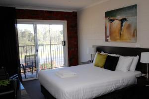 a hotel room with a bed and a window at Mildura Riverview Motel in Gol Gol