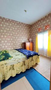 a bedroom with a bed with a yellow bedspread at Penginapan Syariah Dhifa Indonesian only in Bukittinggi