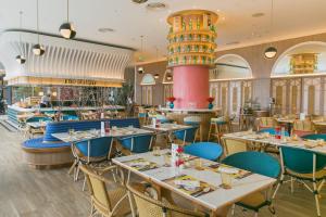 ein Speisesaal mit Tischen und Stühlen und ein Restaurant in der Unterkunft Centara Grand At CentralWorld in Bangkok