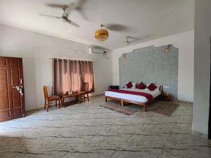 a bedroom with a bed and a table and chairs at Jawai Wildlife Safari Camp in Nāna