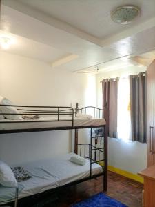 Zimmer mit 2 Etagenbetten und einem Fenster in der Unterkunft Enjoy the City View! in Manila