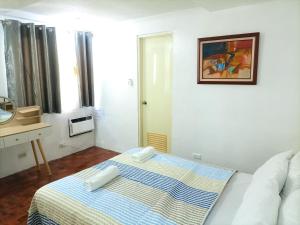 ein Schlafzimmer mit einem Bett mit einer blauen und gelben Decke in der Unterkunft Enjoy the City View! in Manila