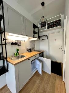 a kitchen with white cabinets and a sink at Savi Apartment 4 in Pärnu