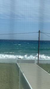 uma vista para o oceano a partir de uma janela de uma praia em Previllage RED Apartment em Kardamaina
