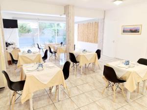 une salle à manger avec des tables, des chaises et un tissu de table jaune dans l'établissement G92 City Hotel, à Rhodes