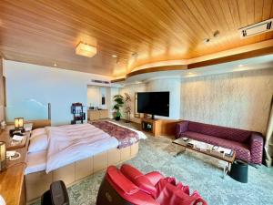 ein großes Schlafzimmer mit einem großen Bett und einem Sofa in der Unterkunft SKY Tower Sweet 4 Beppu, Resort Love Hotel in Beppu