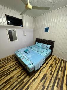 um quarto com uma cama e uma ventoinha de tecto em Homestay Ummie 