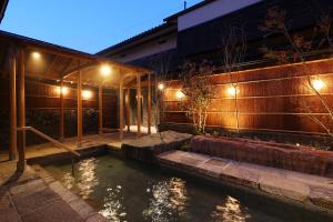 einen Teich vor einem Gebäude in der Nacht in der Unterkunft Monjusou in Miyazu