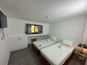een kleine kamer met 2 bedden en een raam bij Generosa Beach Club in Bauang