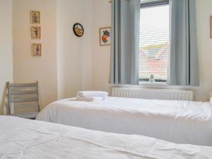 a bedroom with two beds and a window at Harbour Watch in Maryport
