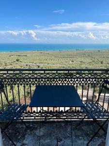 eine blaue Bank auf einem Balkon mit Meerblick in der Unterkunft Villa Basso 2 in Monte SantʼAngelo