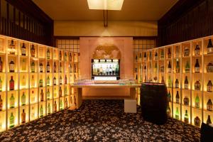 una sala de cata de vinos con una exposición de botellas de vino en Meitei no Yado Hotel Koshien en Fuefuki