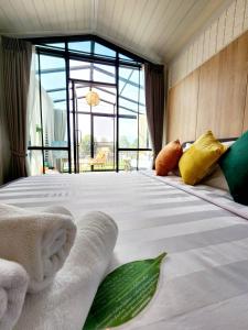 a bedroom with a large bed with towels on it at Capital O 75422 Million Pillows in Chiang Mai