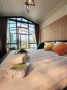a bedroom with a large bed with a large window at Capital O 75422 Million Pillows in Chiang Mai