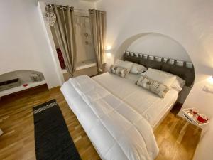 uma grande cama branca num quarto com uma janela em Loft Nineteen Apartment em La Spezia