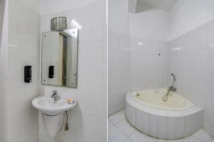 een witte badkamer met een wastafel en een bad bij FabHotel Prime Rockstar Suites in Calcutta