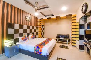 a bedroom with a bed and a desk and a television at FabHotel Prime Rockstar Suites in Kolkata