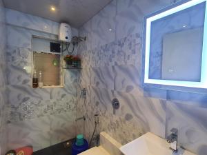 OSI Apartments Andheri East في مومباي: حمام مع حوض ومرآة