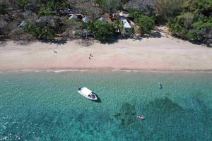un barco en el agua junto a una playa en Le Jardin Maore, en Kani Keli