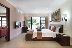 a bedroom with a bed and a tv in it at Peninsula Bay Resort in Nusa Dua +54 photos