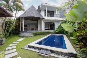a house with a swimming pool in front of a house at The Bidadari Villas and Spa Umalas - CHSE Certified in Canggu