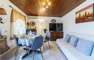 sala de estar con mesa y sofá en Beautiful Home In Pula With 2 Bedrooms And Wifi en Pinezići